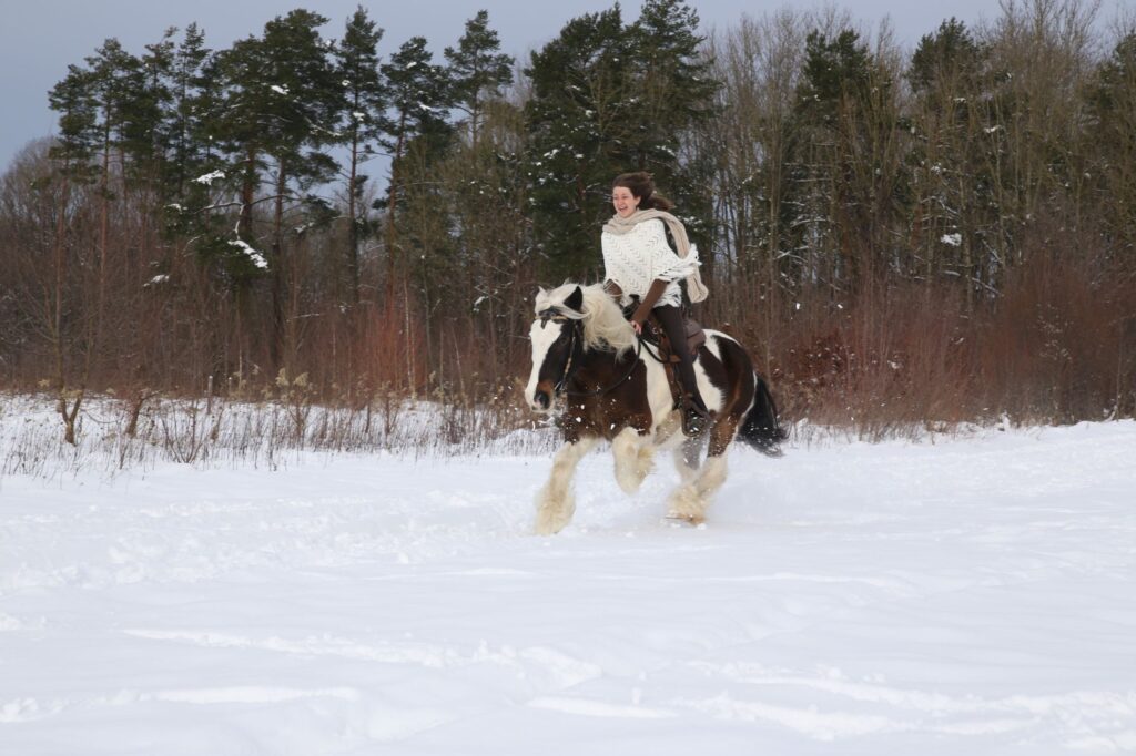 Mira Glückler reitet mit ihrem Pflegepferd durch eine verschneite Landschaft